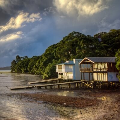 Photo of a home with a dock in a beach, with overcast skies